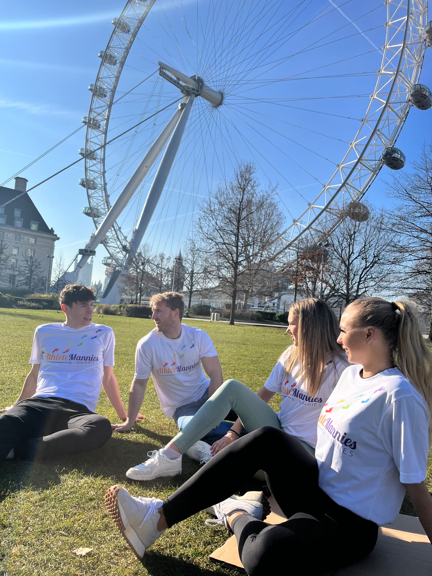 Athlete Mannies and Nannies carers relaxing on the grass by the London Eye