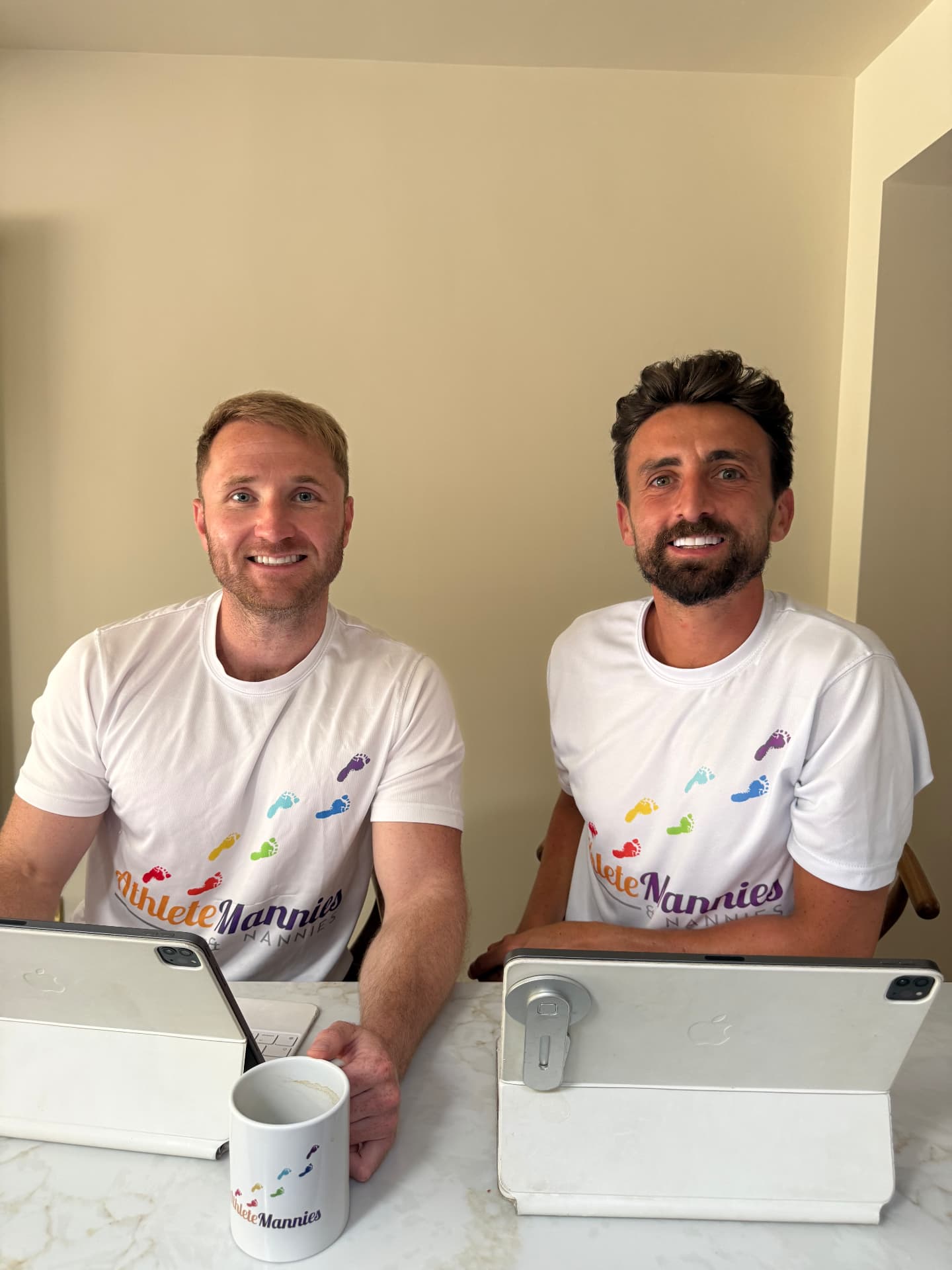 The two founders of Athlete Mannies & Nannies at a table with tablets
